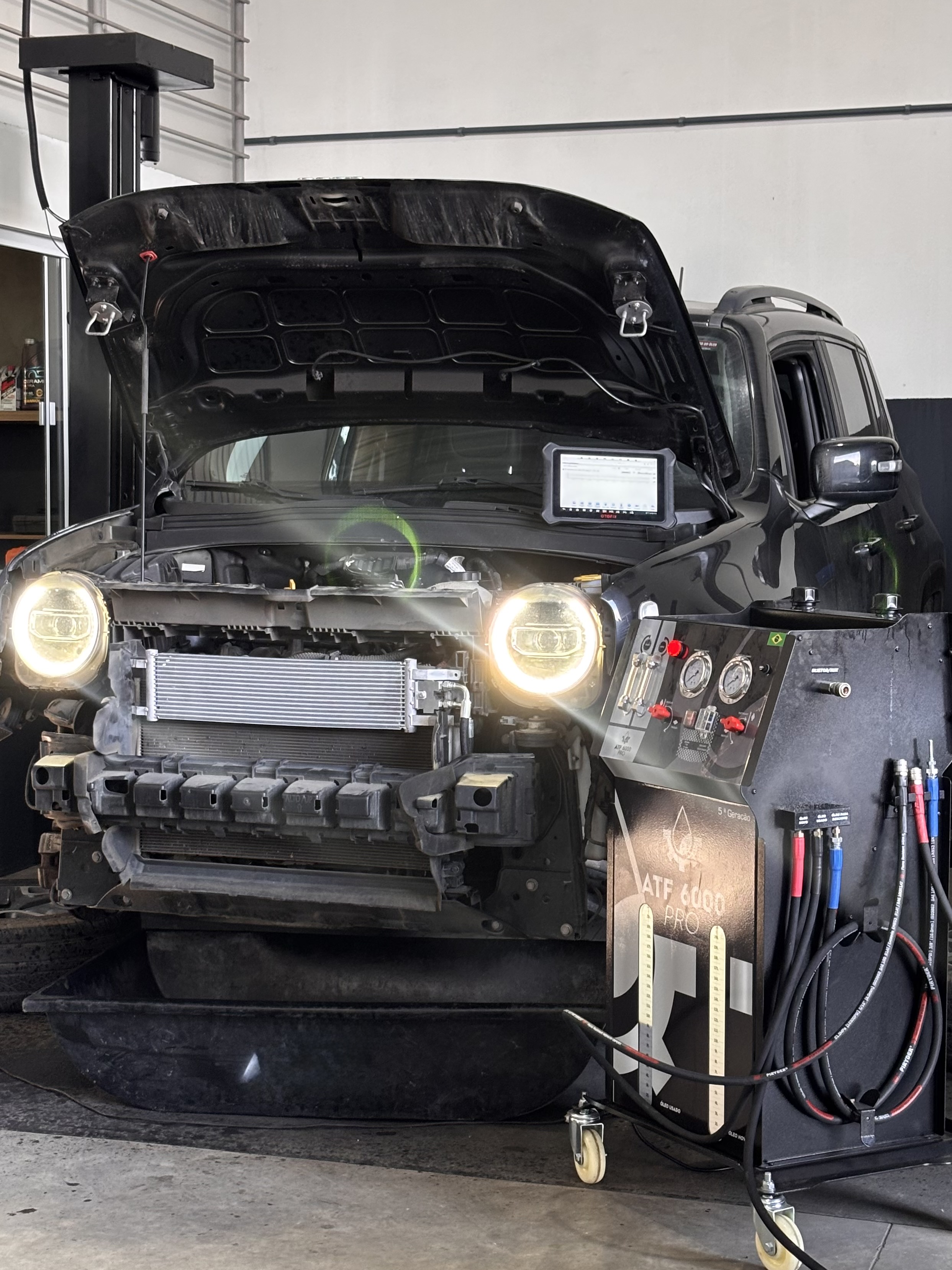 Procedimento de upgrade do radiador de óleo da transmissão automática em veículo da linha Jeep, realizado para melhorar o controle da temperatura do fluido do câmbio.